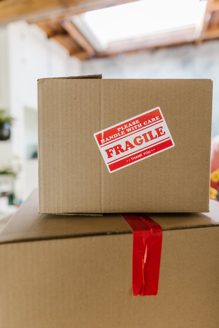 cta-02 Close-up of cardboard boxes stacked with fragile care label in an indoor setting.